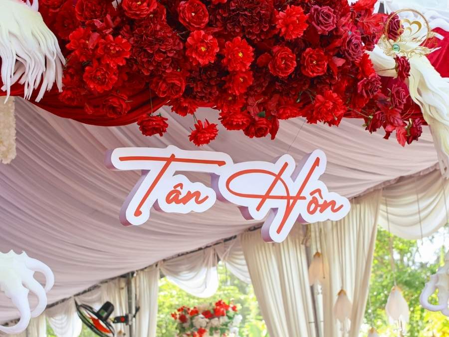 Bảng chữ Tân Hôn tone đỏ trên cổng hoa Rồng Phụng được trang trí hoa lụa cao cấp.