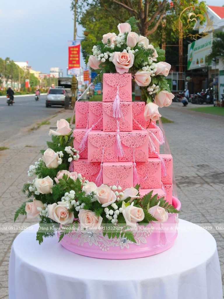 Mâm bánh cupcake trang trí hoa tươi tone hồng.