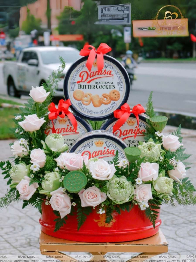 Mấm bánh danisa trang trí hoa tươi tone sen.