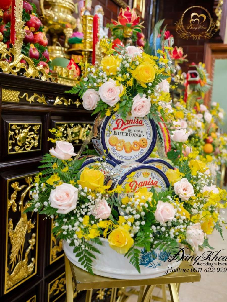 Mâm bánh danisa trang trí hoa tươi tone vàng.