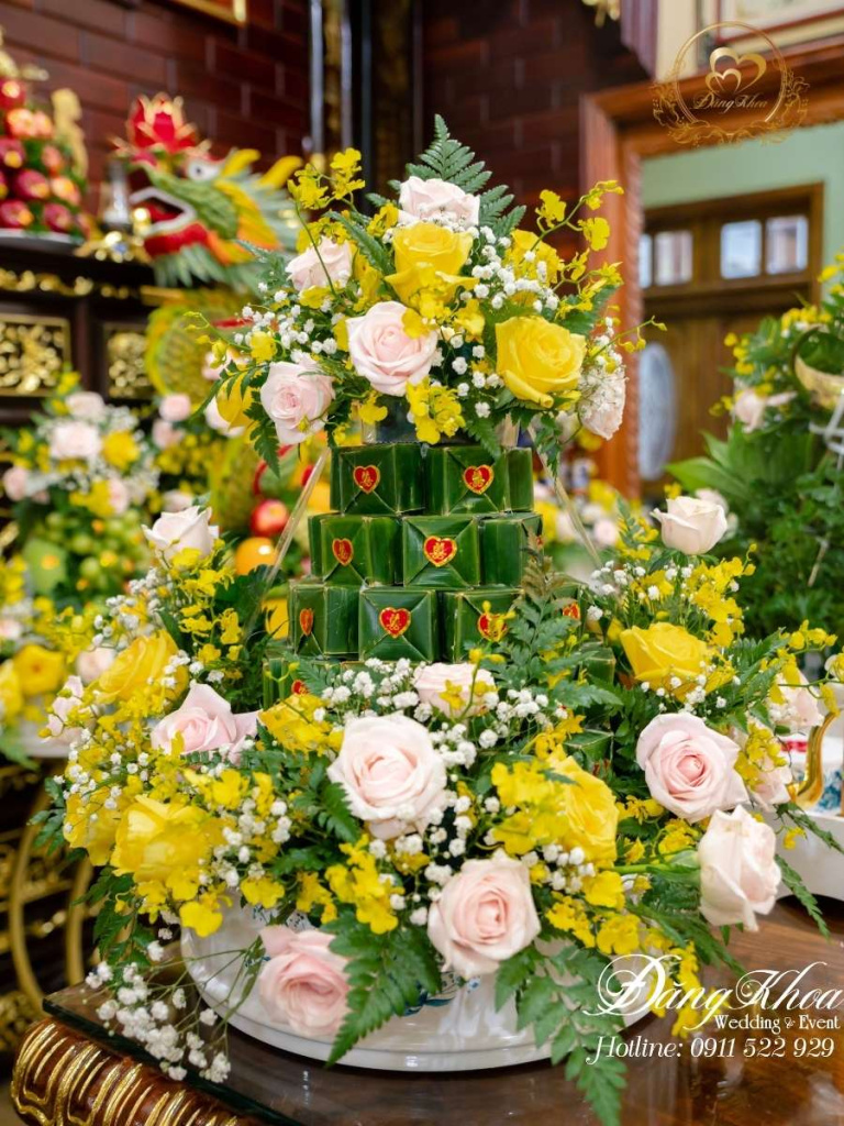 Mâm bánh phu thê trang trí hoa tươi tone vàng.