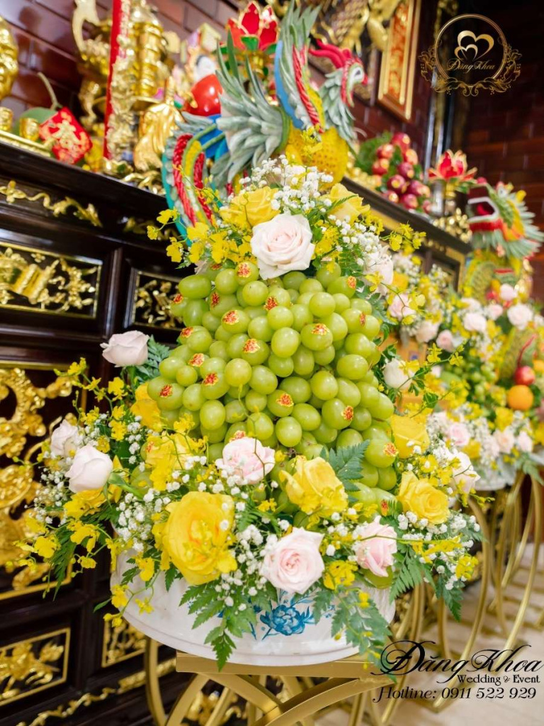 Mâm nho xanh trang trí hoa tươi tone vàng.