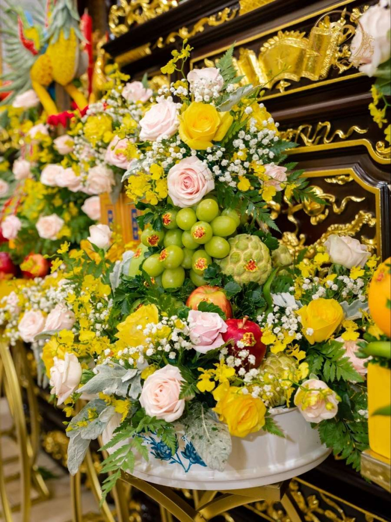 Mâm trái cây trang trí hoa tươi tone vàng.