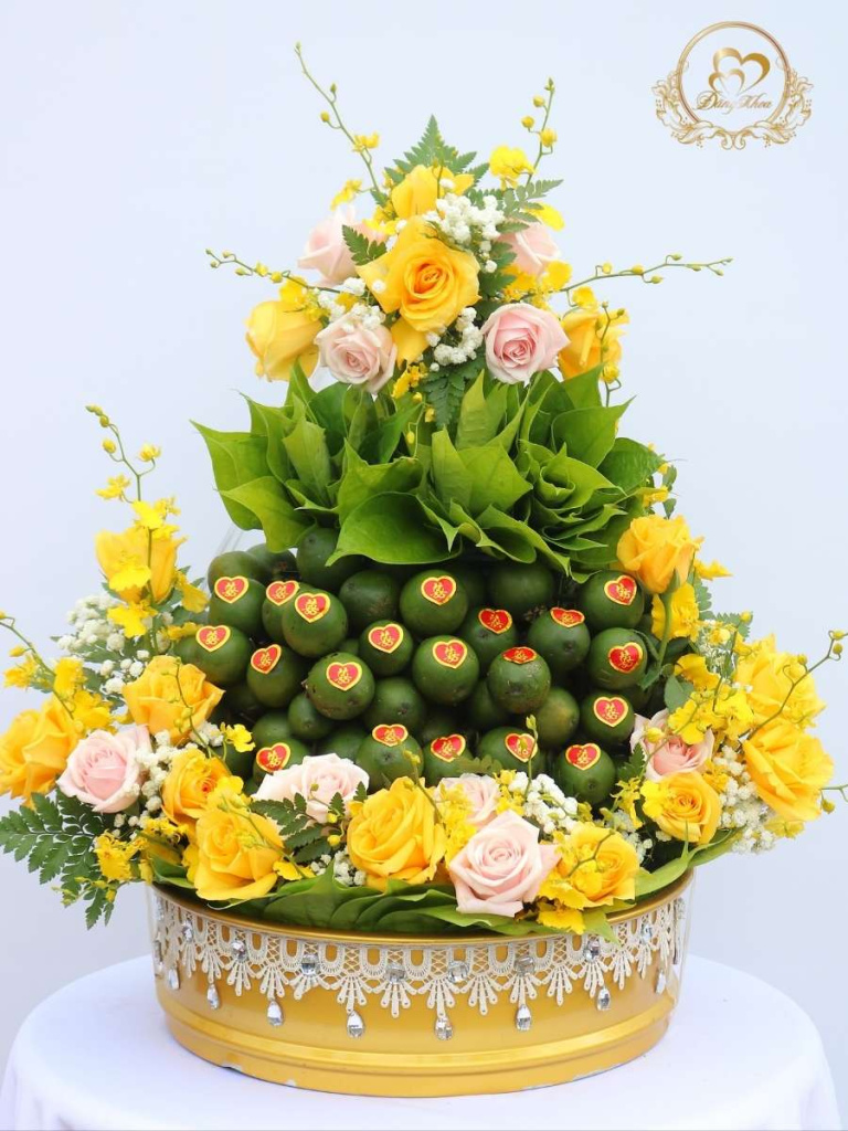 Mâm trầu cau trang trí hoa tươi tone vàng.