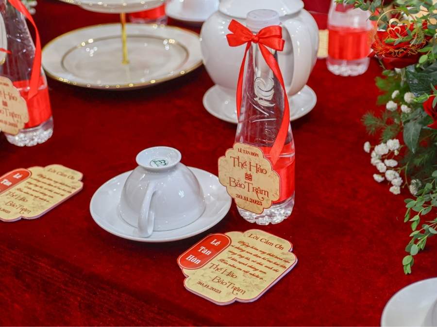 Tem nước suối thiết kế nơ đỏ in tên cô dâu chú rể.