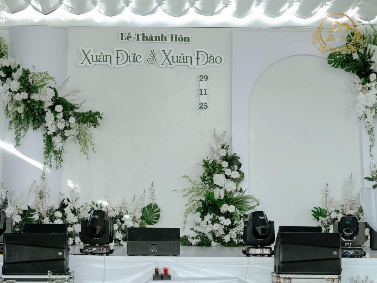 Sân khấu cưới ngoài trời tone trắng xanh lá.