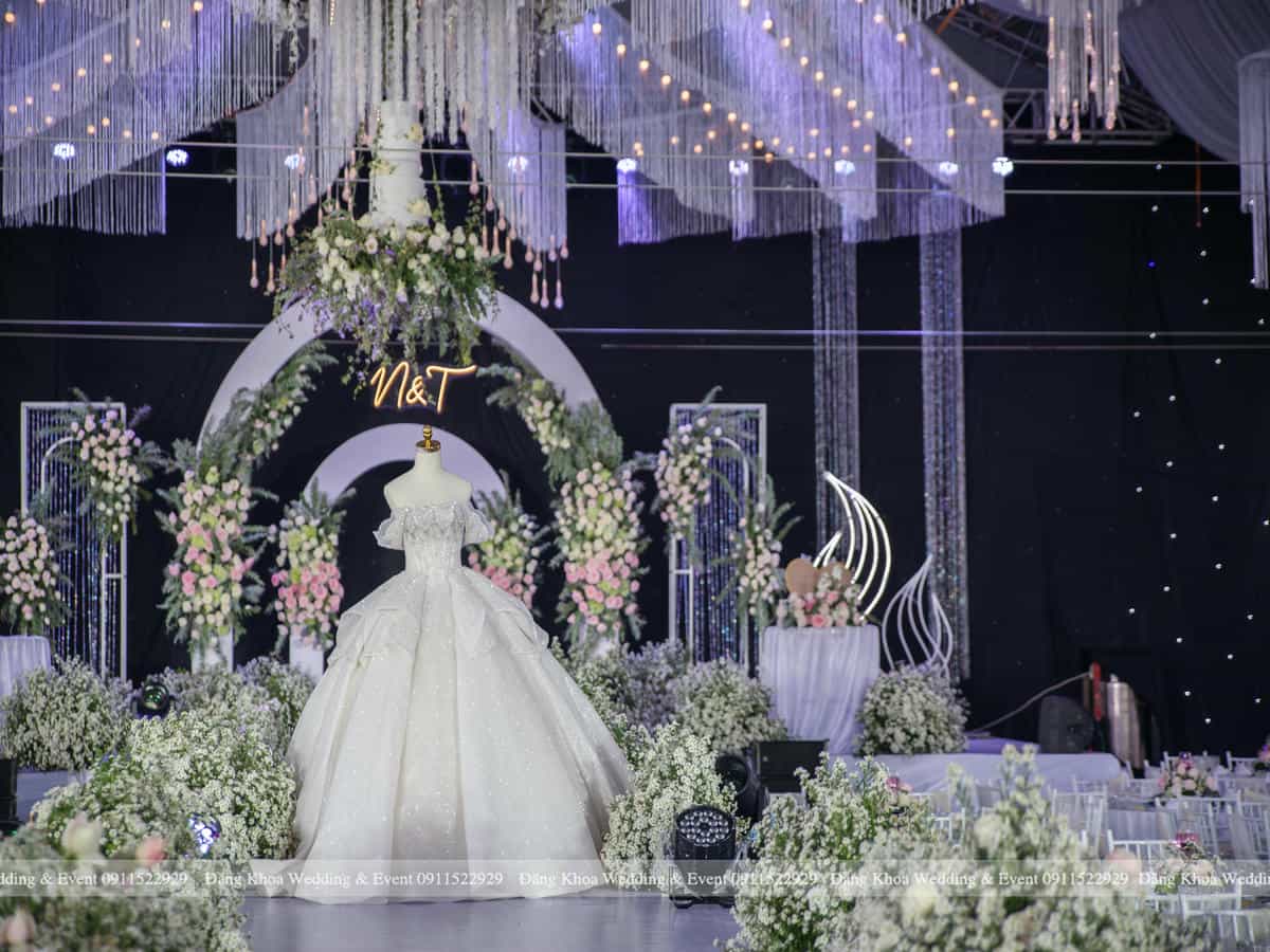 Trưng bày váy cưới trên sàn Catwalk phủ đầy hoa bi trắng.
